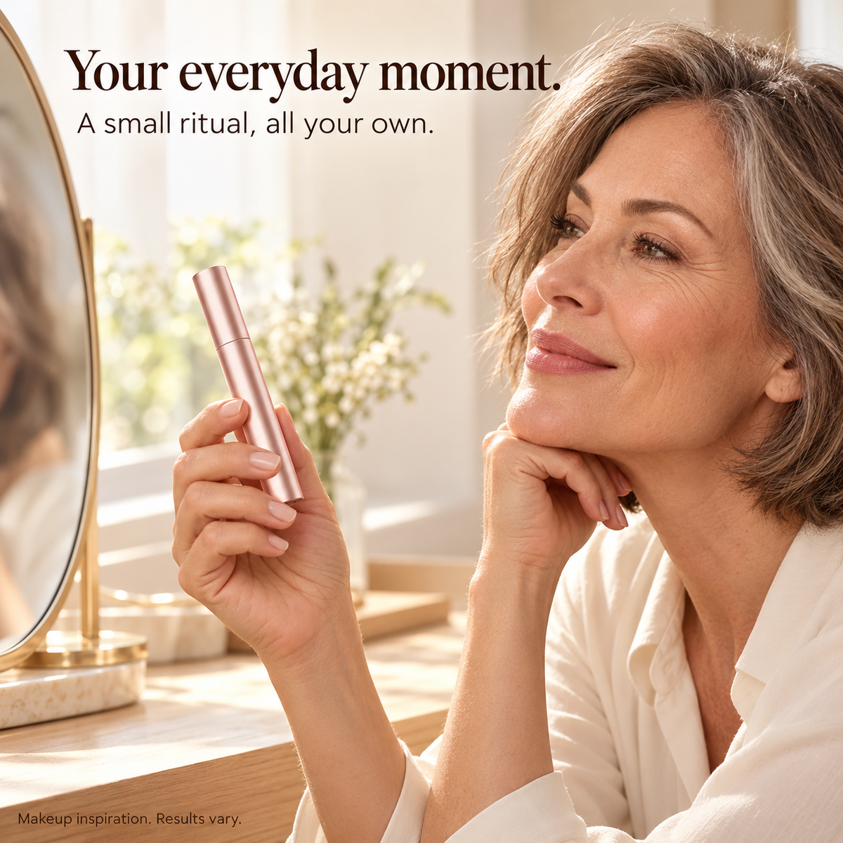 Mature woman with rose-gold mascara in a warm morning vanity setting